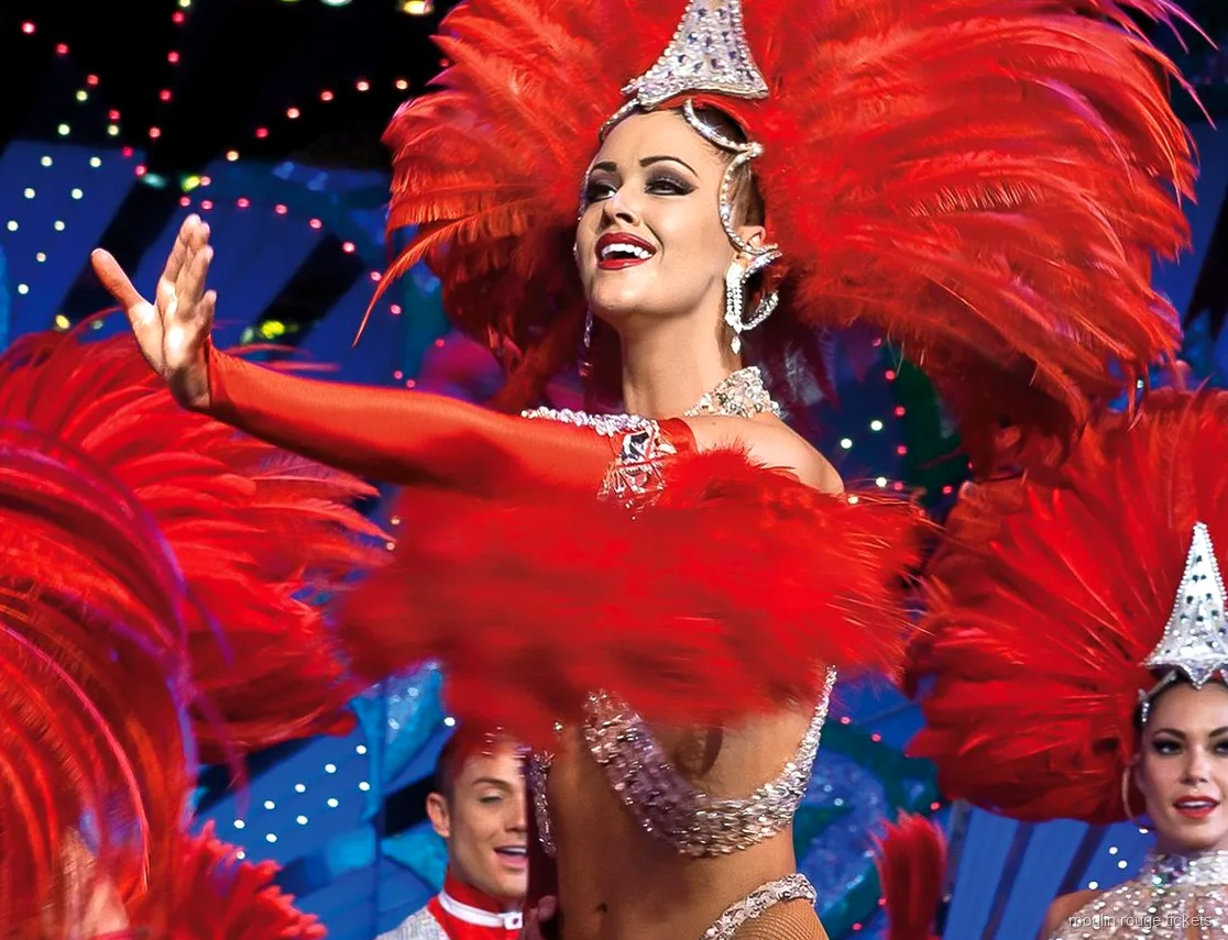 Biglietti Moulin Rouge: ballerina con copricapo di piume rosse e paillettes sotto le luci del palco