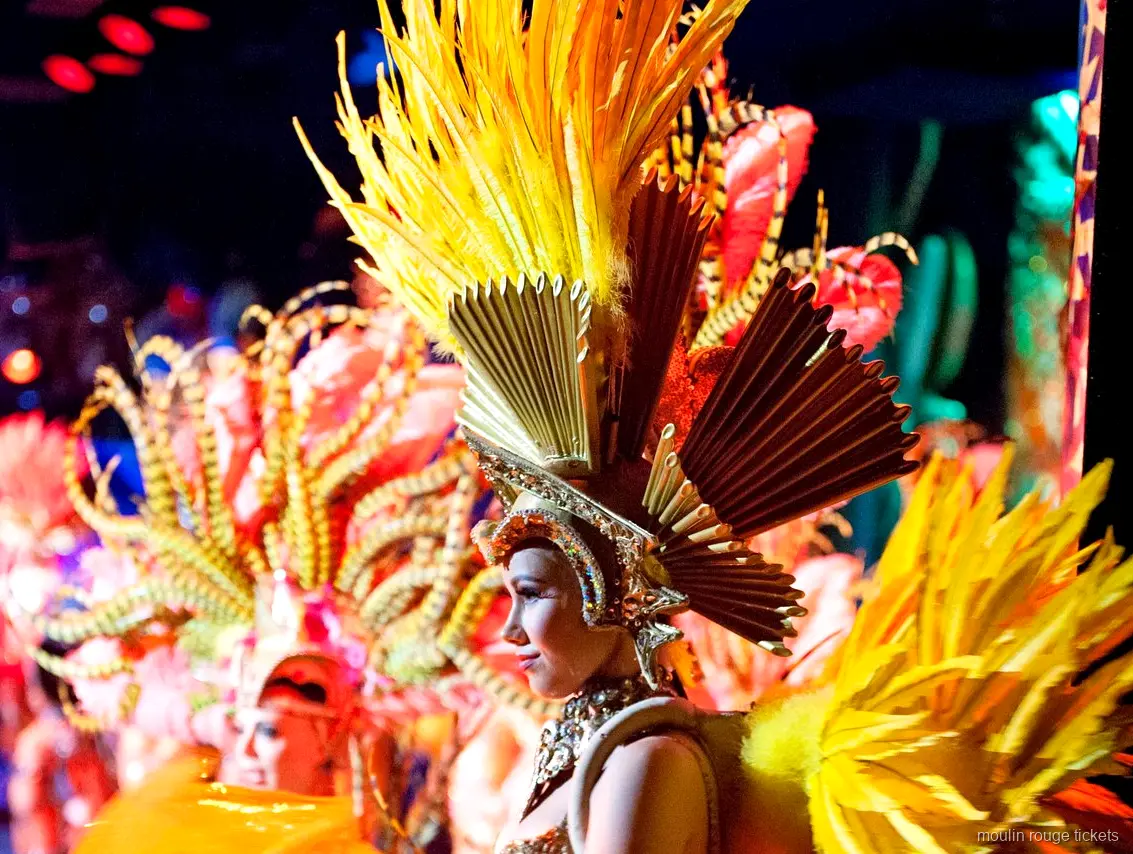 Billets Moulin Rouge : danseuse coiffée de plumes dorées et d'une couronne en éventail sur scène