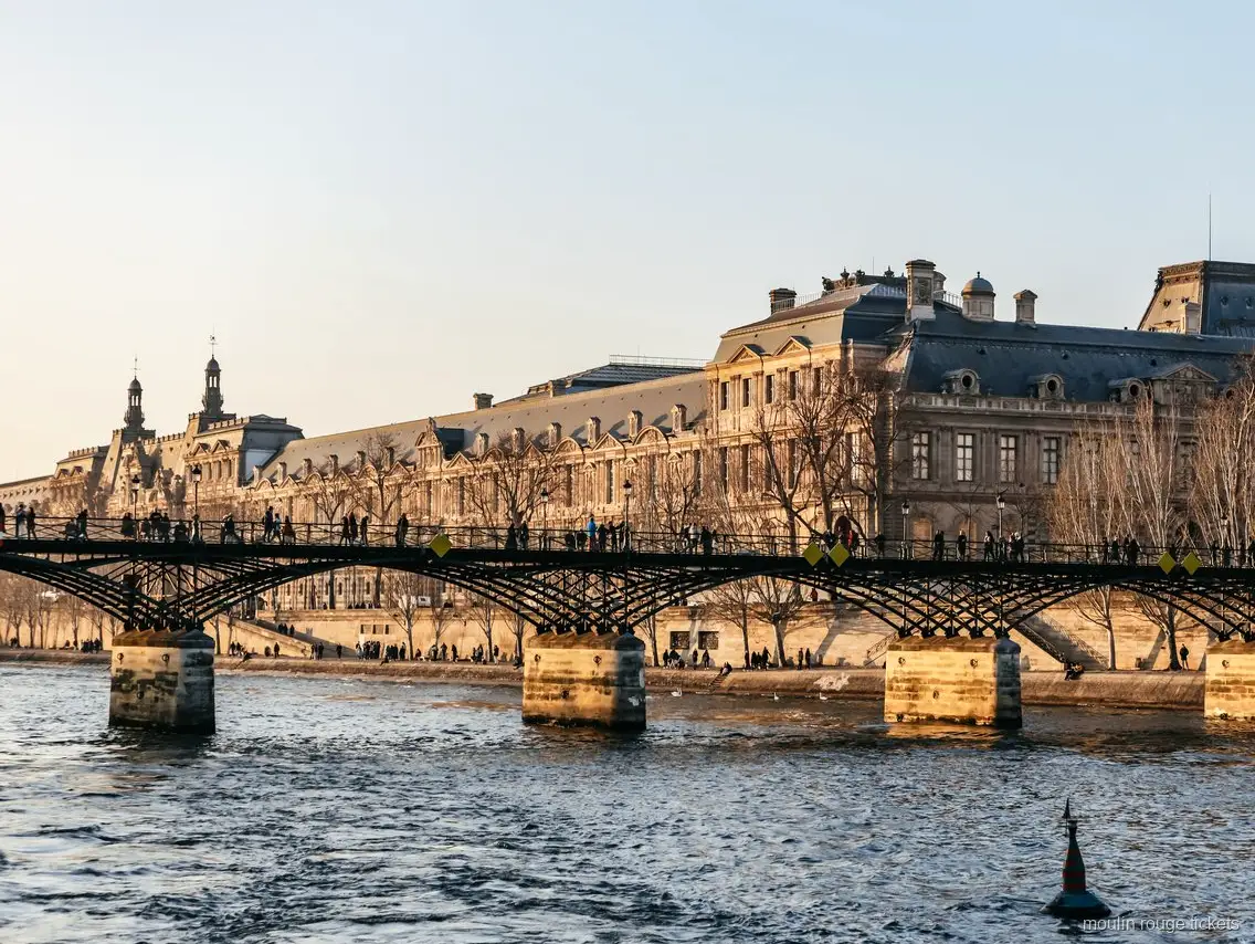 Pont des Arts y el Louvre desde el Sena al atardecer, crucero combinado con entradas Moulin Rouge