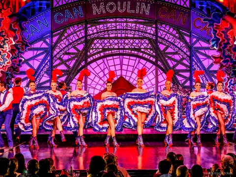 Danseuse de cancan en grand écart sauté, jupon bleu à volants, avec son partenaire, dîner spectacle Moulin Rouge