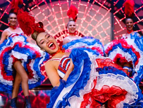 Danseuse de cancan riant, jupon à volants bleu blanc rouge levé, billets dîner spectacle Moulin Rouge