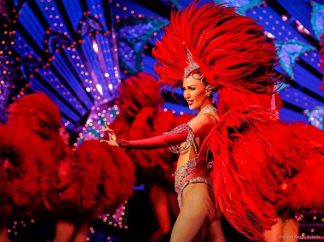 Bailarina con un gran abanico de plumas rojas ante un decorado azul iluminado, entradas Moulin Rouge