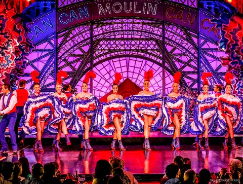 Dançarina de cancã em salto espacate com saia azul de babados e parceiro, jantar e show Moulin Rouge