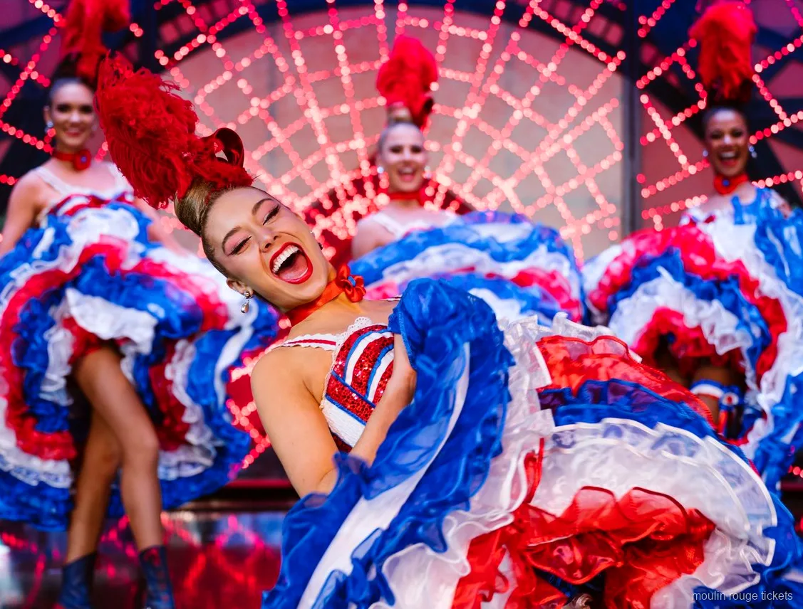 Roześmiana tancerka kankana w czerwono-biało-niebieskiej spódnicy z falbanami, bilety Moulin Rouge z kolacją