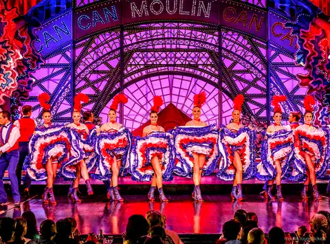 Cancan dancer in a mid-air split with a blue ruffled skirt and a partner, Moulin Rouge dinner show tickets