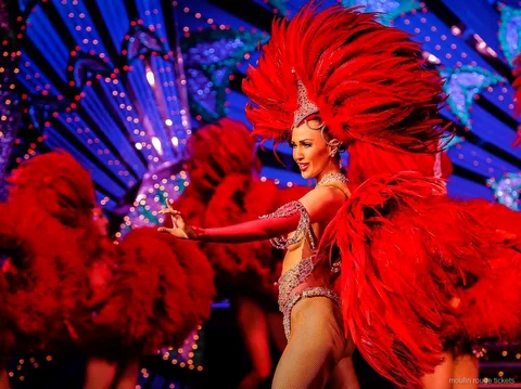 Danseres met een grote rode verenwaaier voor een blauw verlicht decor, Moulin Rouge showtickets