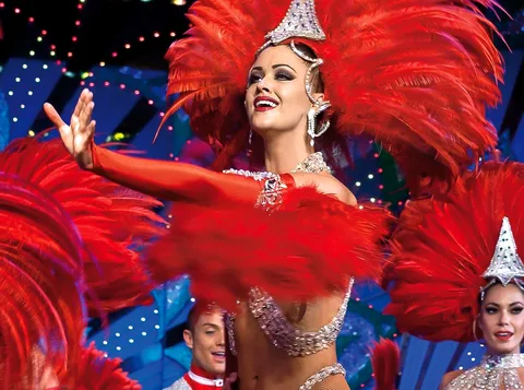 Moulin Rouge billetter: danser med rødt fjerhovedtøj og pailletter under scenelysene