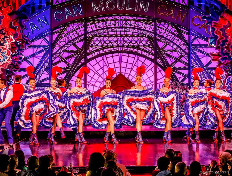 ライトアップされたMOULINの看板の下でトリコロールのスカートを揺らして一列に並ぶフレンチカンカン、ムーランルージュ チケット