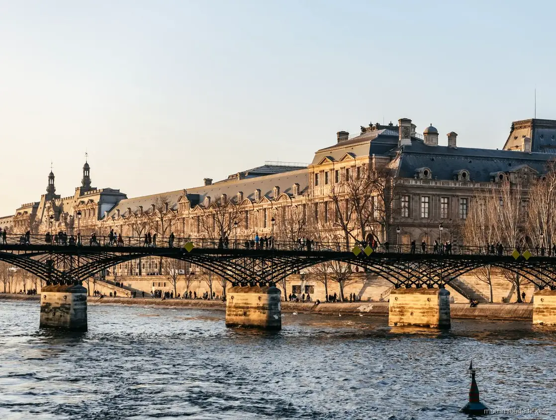 Pont des Arts og Louvre set fra Seinen ved solnedgang, sejltur kombineret med Moulin Rouge billetter