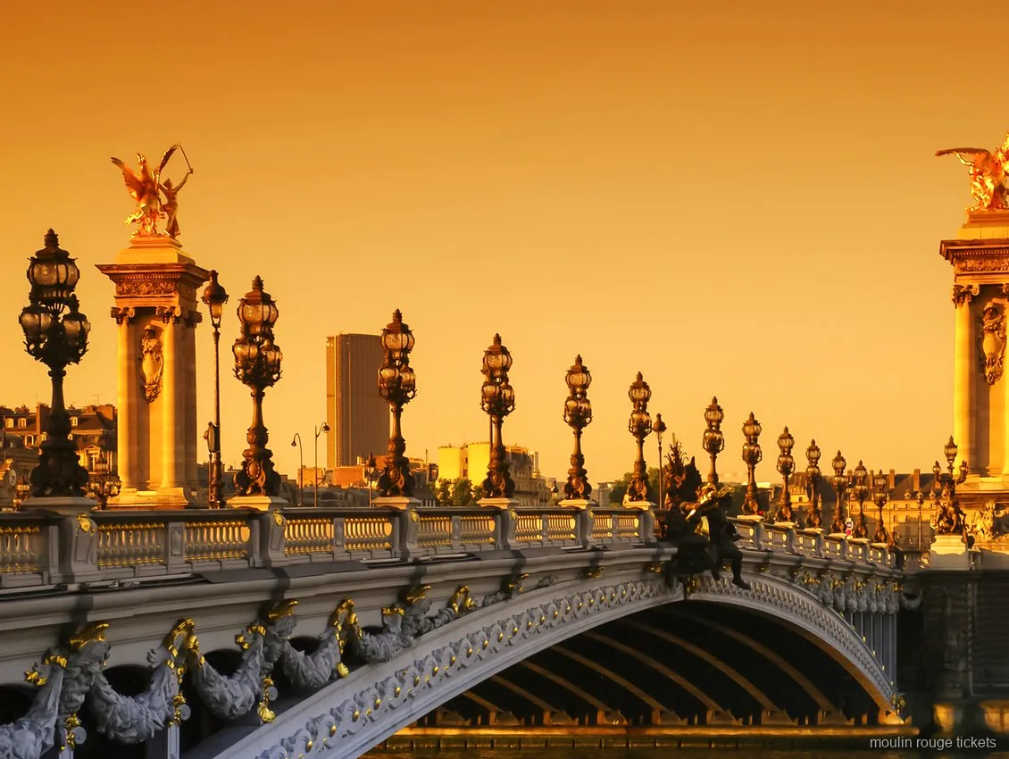 Pont Alexandre III amb estàtues daurades i fanals ornamentats a la posta de sol, vista del tour amb entrades al Moulin Rouge