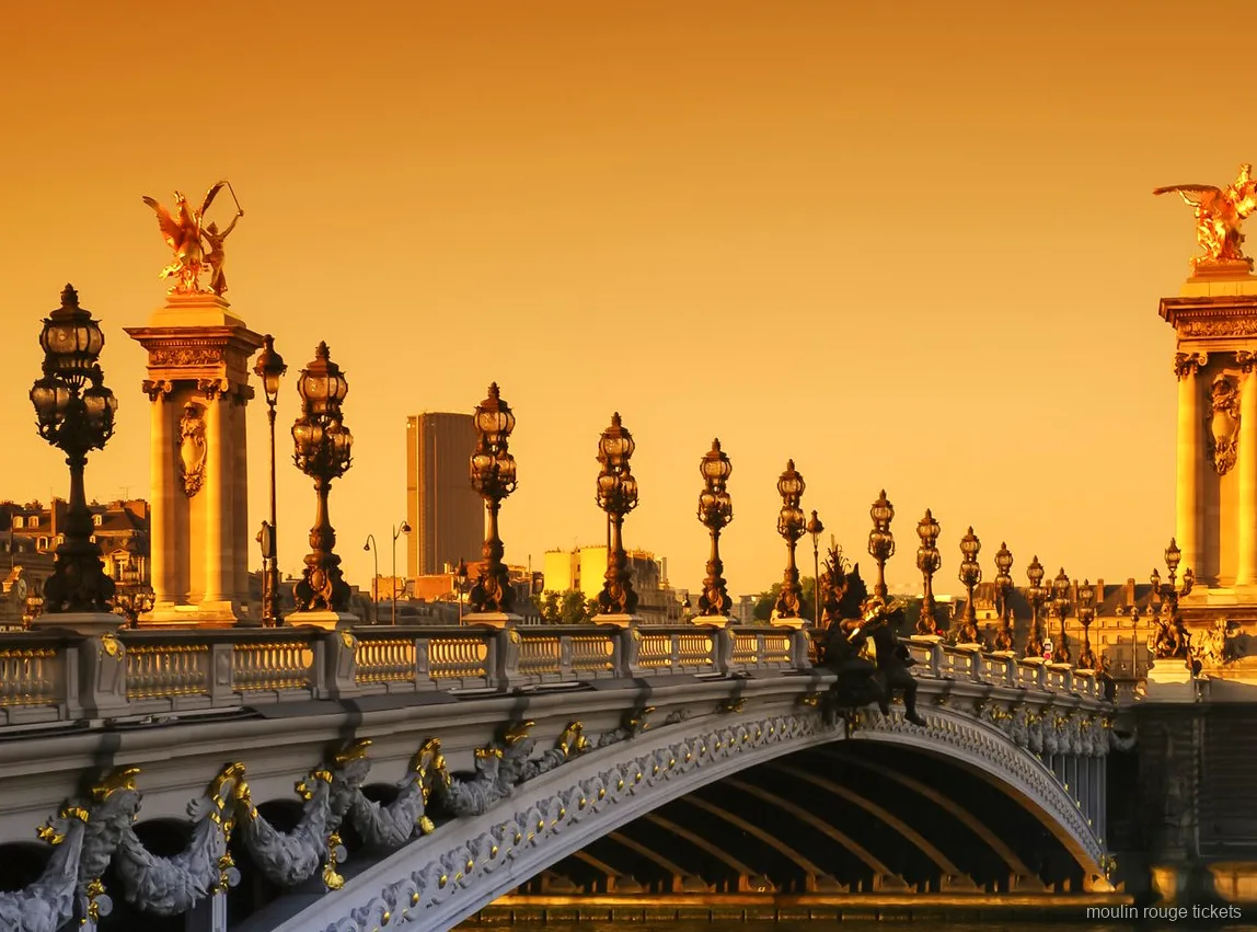 Ponte Alexandre III com estátuas douradas e postes ornamentados ao pôr do sol, vista do passeio com bilhetes Moulin Rouge