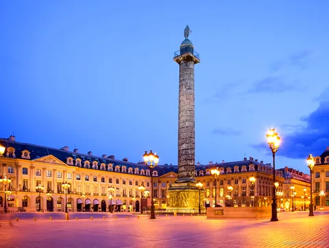 Plaza Vendôme al anochecer con su columna y farolas encendidas, parada del tour con entradas Moulin Rouge