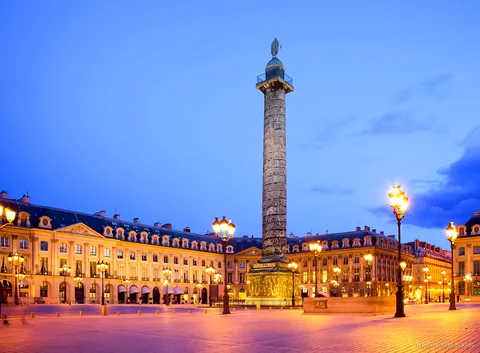 Place Vendôme au crépuscule avec sa colonne et ses lampadaires allumés, étape du tour avec billets Moulin Rouge