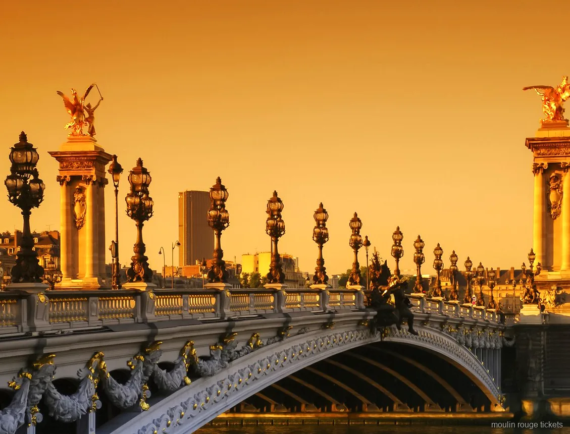 Pont Alexandre III avec statues dorées et lampadaires ornés au coucher du soleil, vue du tour avec billets Moulin Rouge