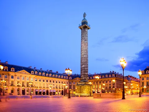 Plac Vendôme o zmierzchu z wysoką kolumną i zapalonymi latarniami, przystanek wycieczki z biletami Moulin Rouge